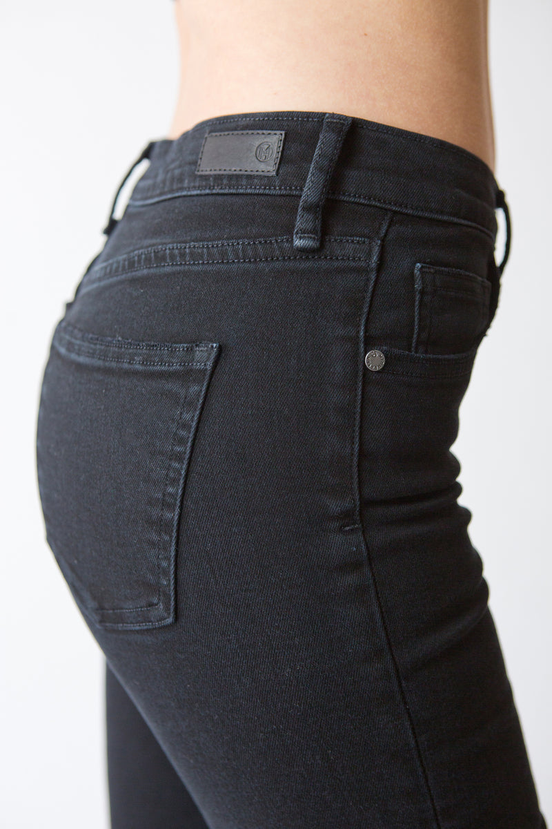 Side View Up Close of Midheaven's Mid-Rise Black Skinny  Details: Rise: 9” Inseam: 33” Leg Opening: 10.5” Fabric contents: 98%Cotton - 2%Elastane     Note: We suggest sizing up. The Astrid runs small.
