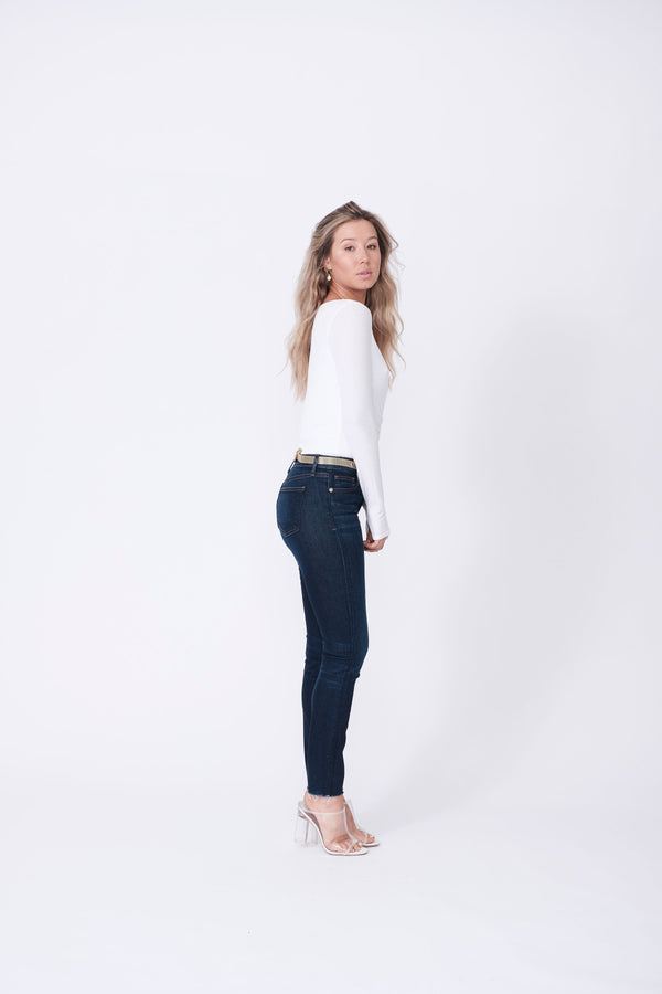 Side View of Midheaven's Mid-Rise Raw Hem Skinny   ITEM RUNS SMALL, CONSIDER SIZING UP   Details: Model is 5’7” and is wearing 4" heels. Rise: 9” Inseam: 28” Leg Opening: 10.5” Fabric contents: 98%Cotton - 2%Elastane