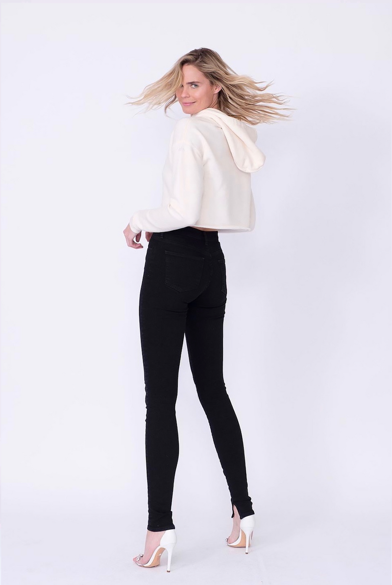 Back View of Midheaven's High-Rise Split Hem Skinny  Details: Model is 6' and is wearing 4" heels. Rise: 10” Inseam: 36” Leg Opening: 10” Fabric contents: 98% Cotton - 2% Elastane