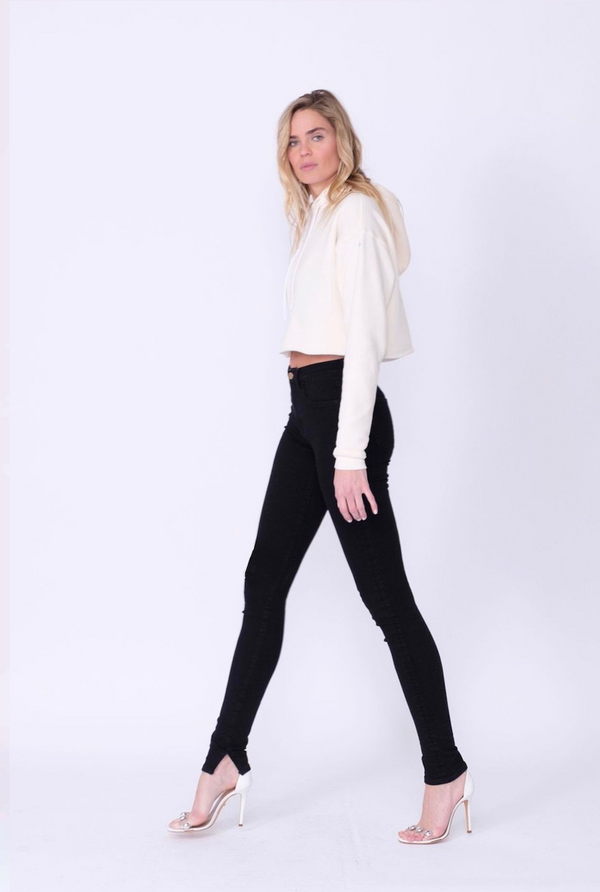 Side View of Midheaven's High-Rise Split Hem Skinny  Details: Model is 6' and is wearing 4" heels. Rise: 10” Inseam: 36” Leg Opening: 10” Fabric contents: 98% Cotton - 2% Elastane