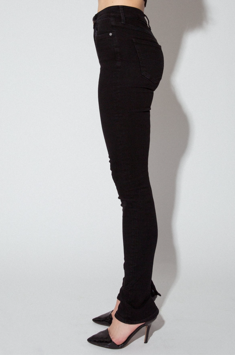 Side View of Midheaven's High-Rise Split Hem Skinny  Details: Model is 6' and is wearing 4" heels. Rise: 10” Inseam: 36” Leg Opening: 10” Fabric contents: 98% Cotton - 2% Elastane
