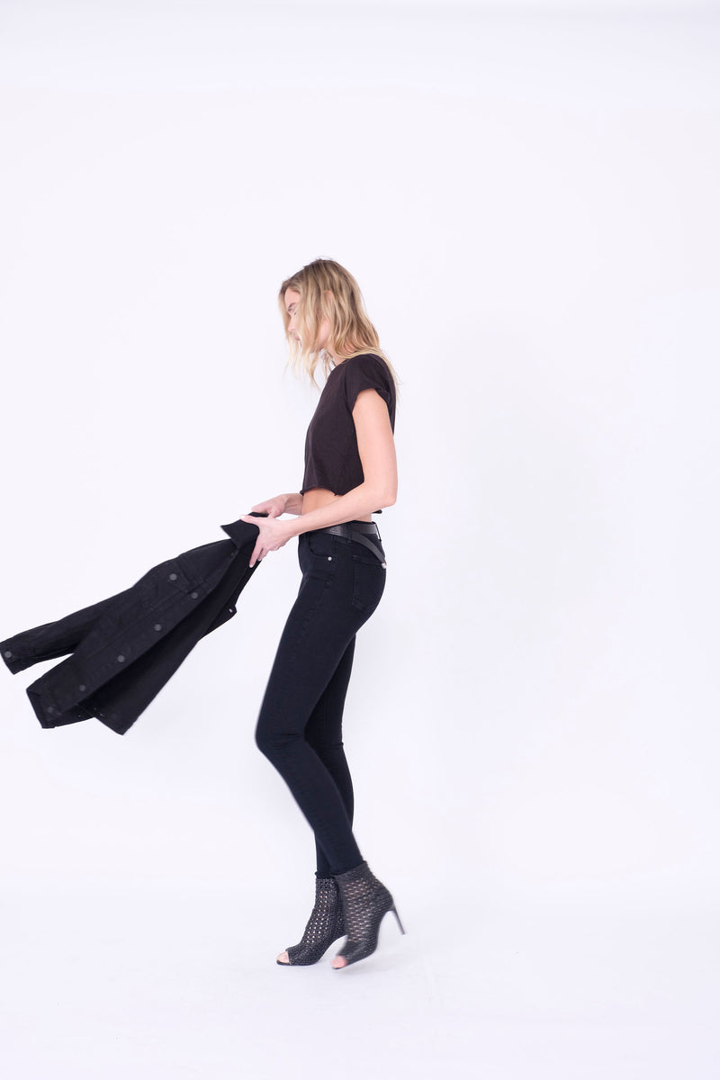 Side View of Midheaven's Mid-Rise Black Skinny  Details: Model is 6' and is wearing 4" heels. Rise: 9” Inseam: 33” Leg Opening: 10.5” Fabric contents: 98%Cotton - 2%Elastane     Note: We suggest sizing up. The Astrid runs small.